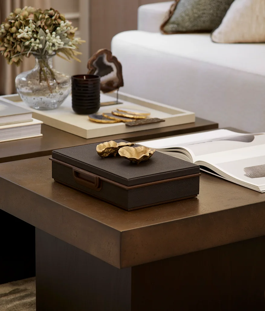 Styled coffee table with decorative objects, books, and soft furnishings in a modern living room.