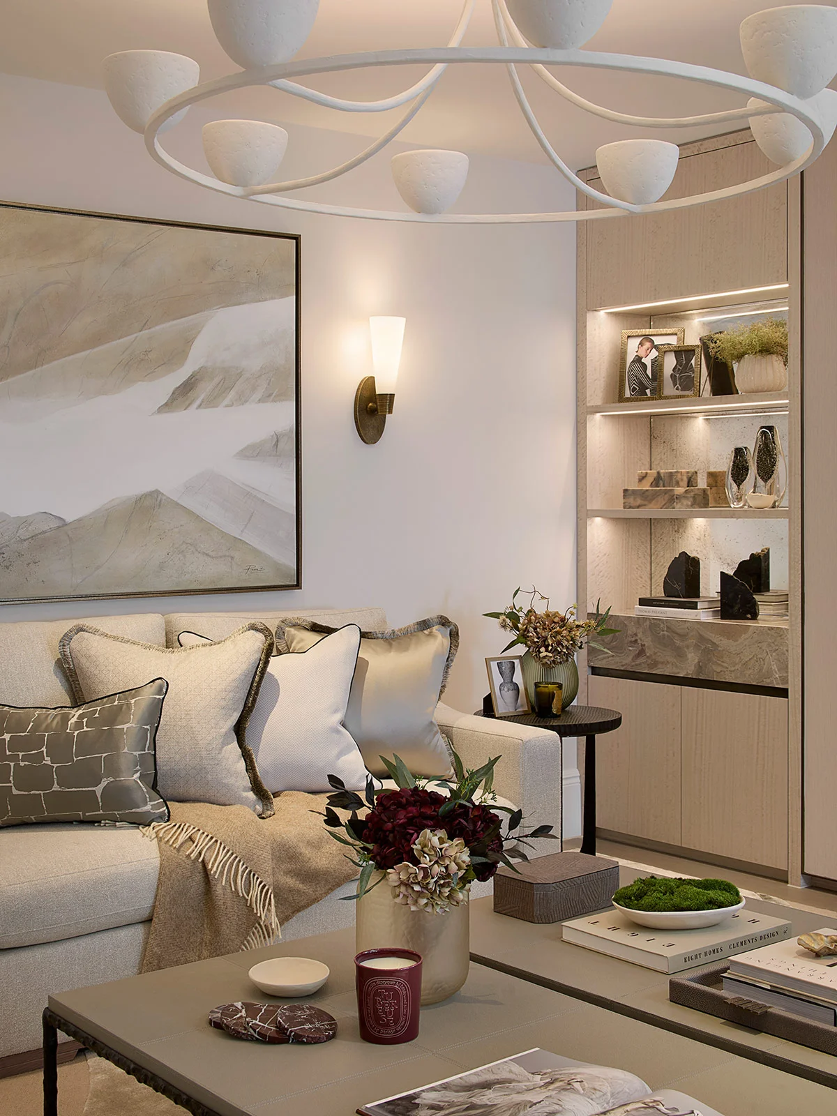 Contemporary living room with bespoke shelving, soft neutral furnishings, and sculptural lighting.