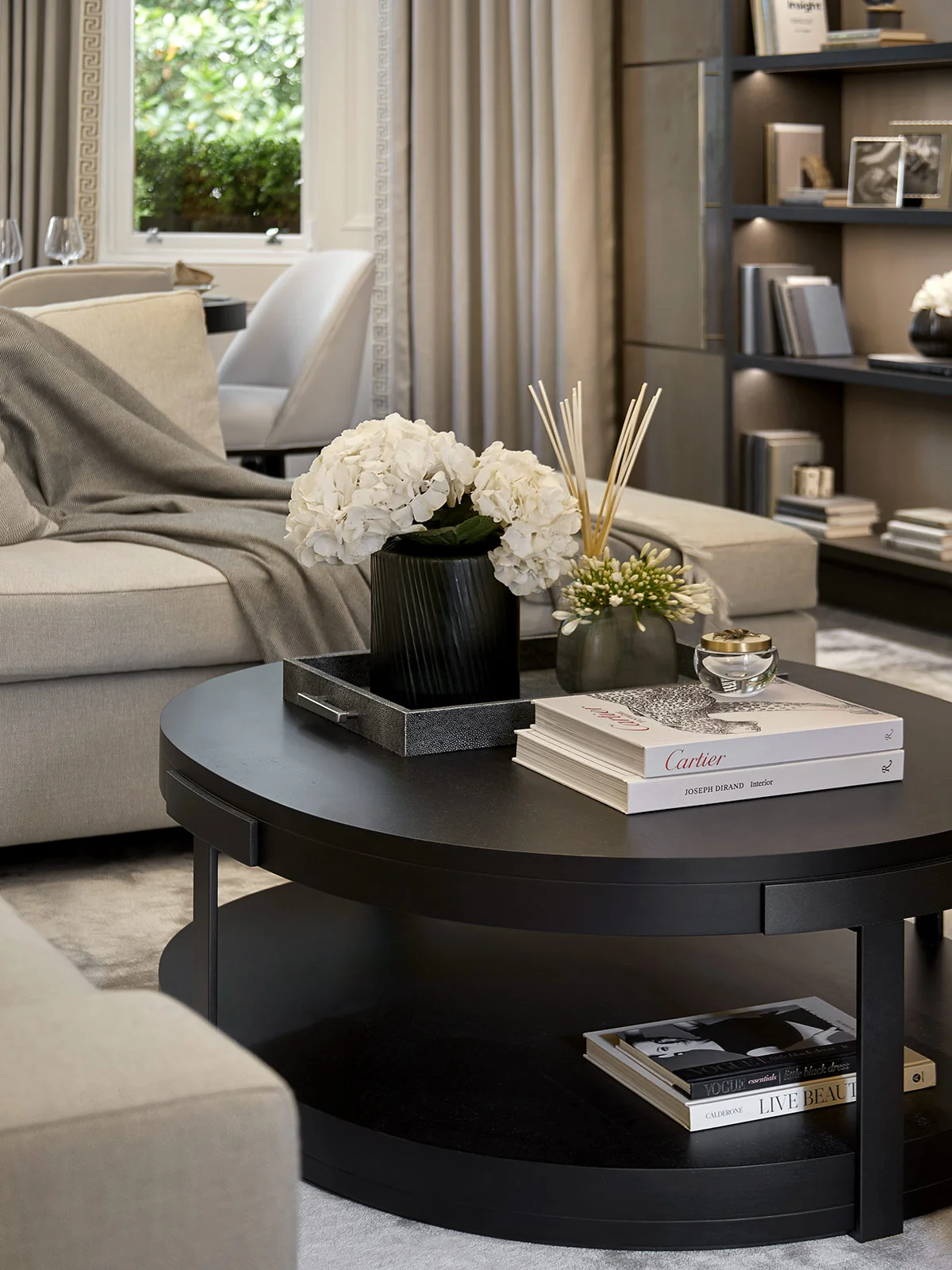 Living room coffee table styled with books, floral arrangement, and decorative accessories.