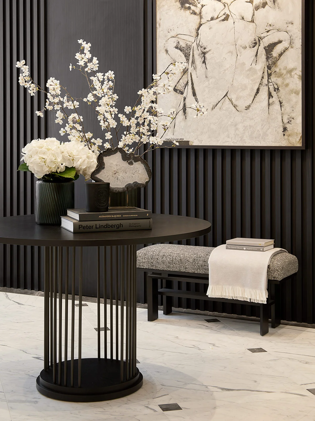 Entrance hall with sculptural console table, floral arrangement, and contemporary artwork.
