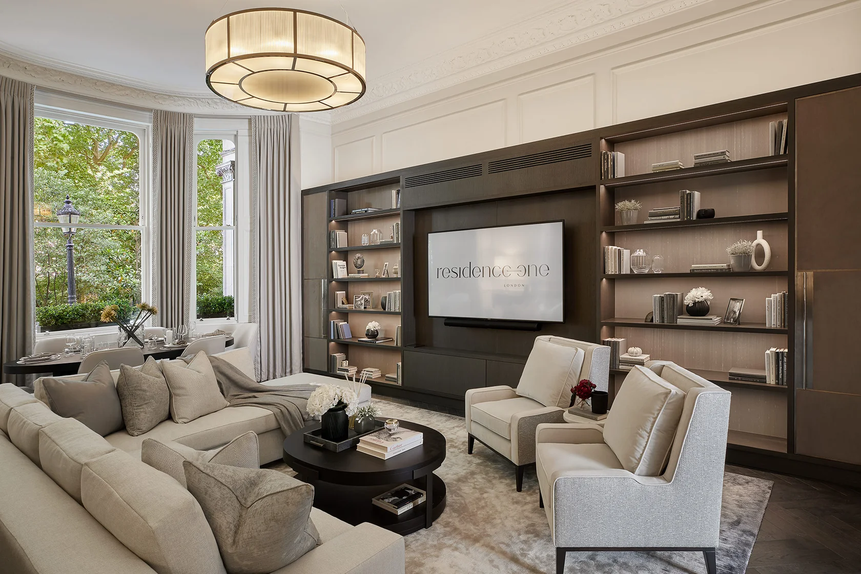 Refined living room featuring bespoke media wall, integrated shelving, and soft neutral furnishings.