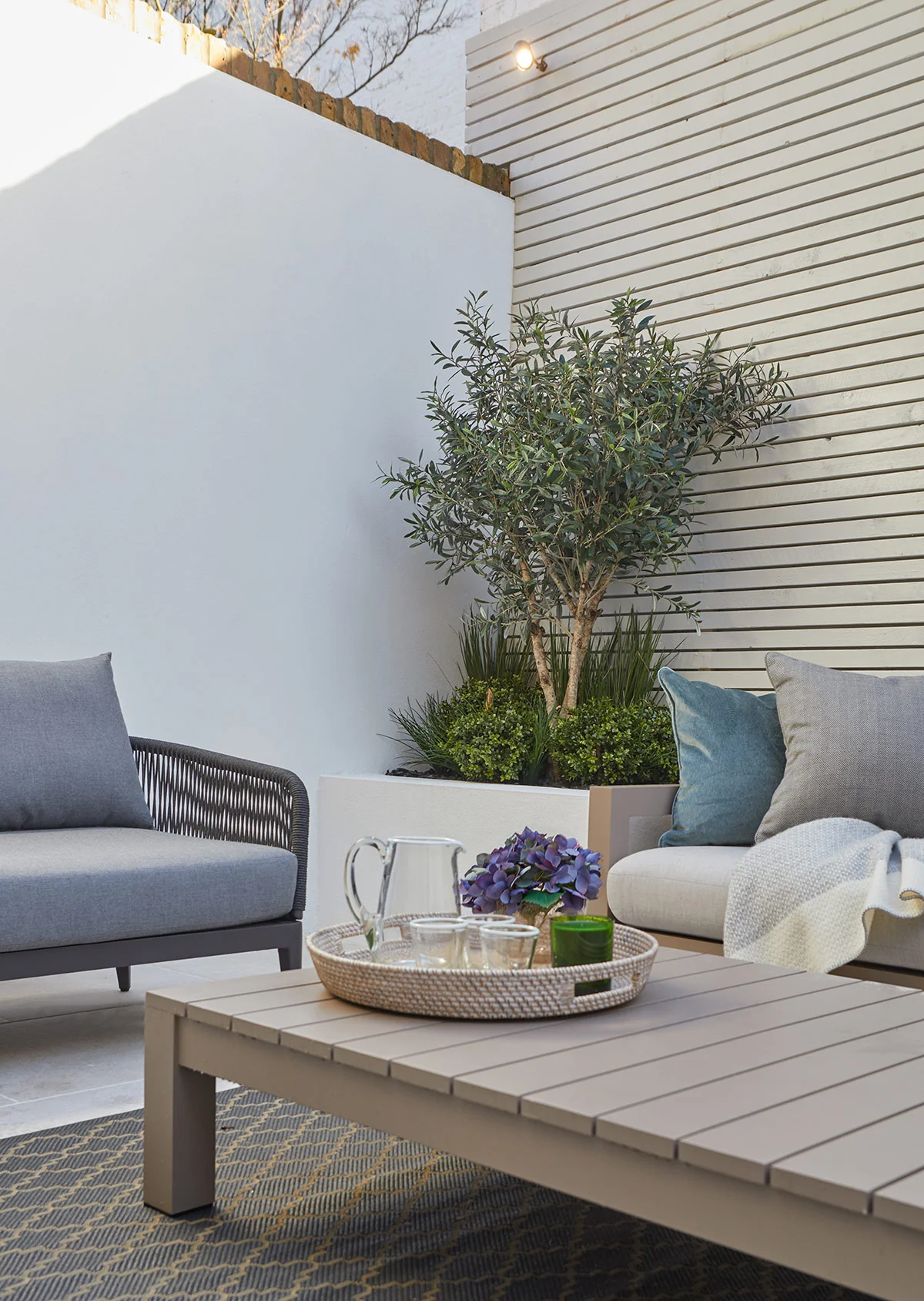 Private courtyard with outdoor seating, integrated planters, and contemporary garden lighting.