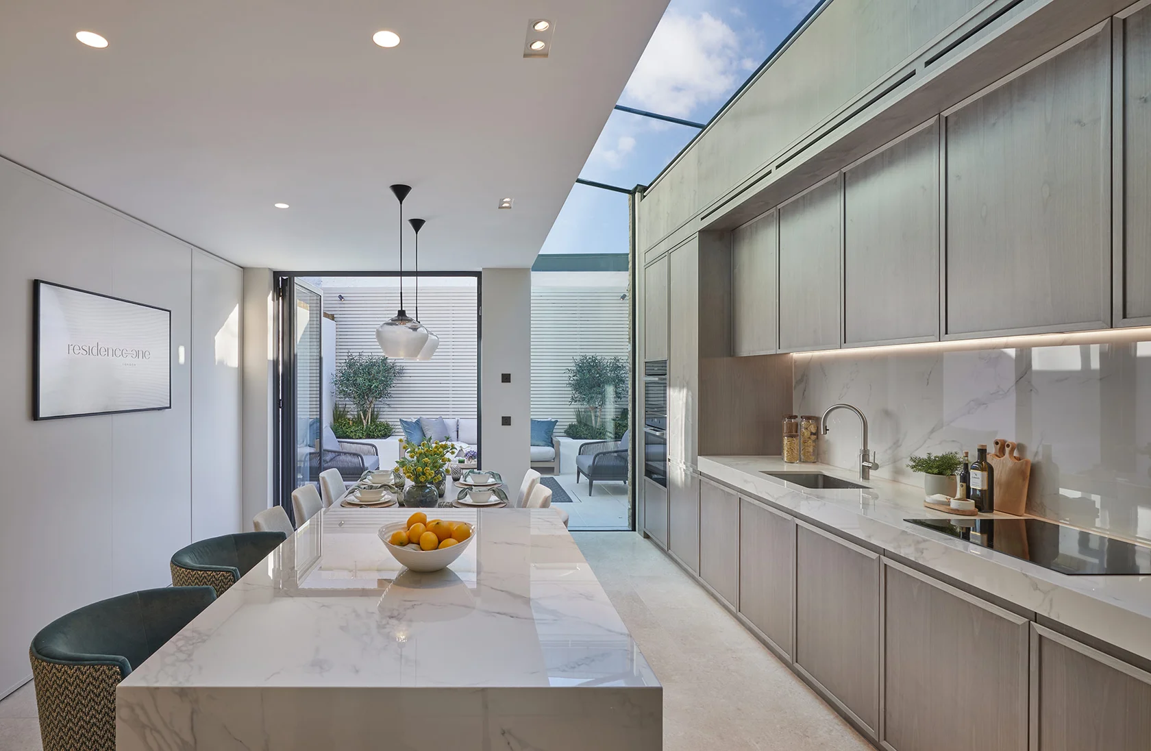 Contemporary kitchen with marble island opening onto a landscaped courtyard terrace.