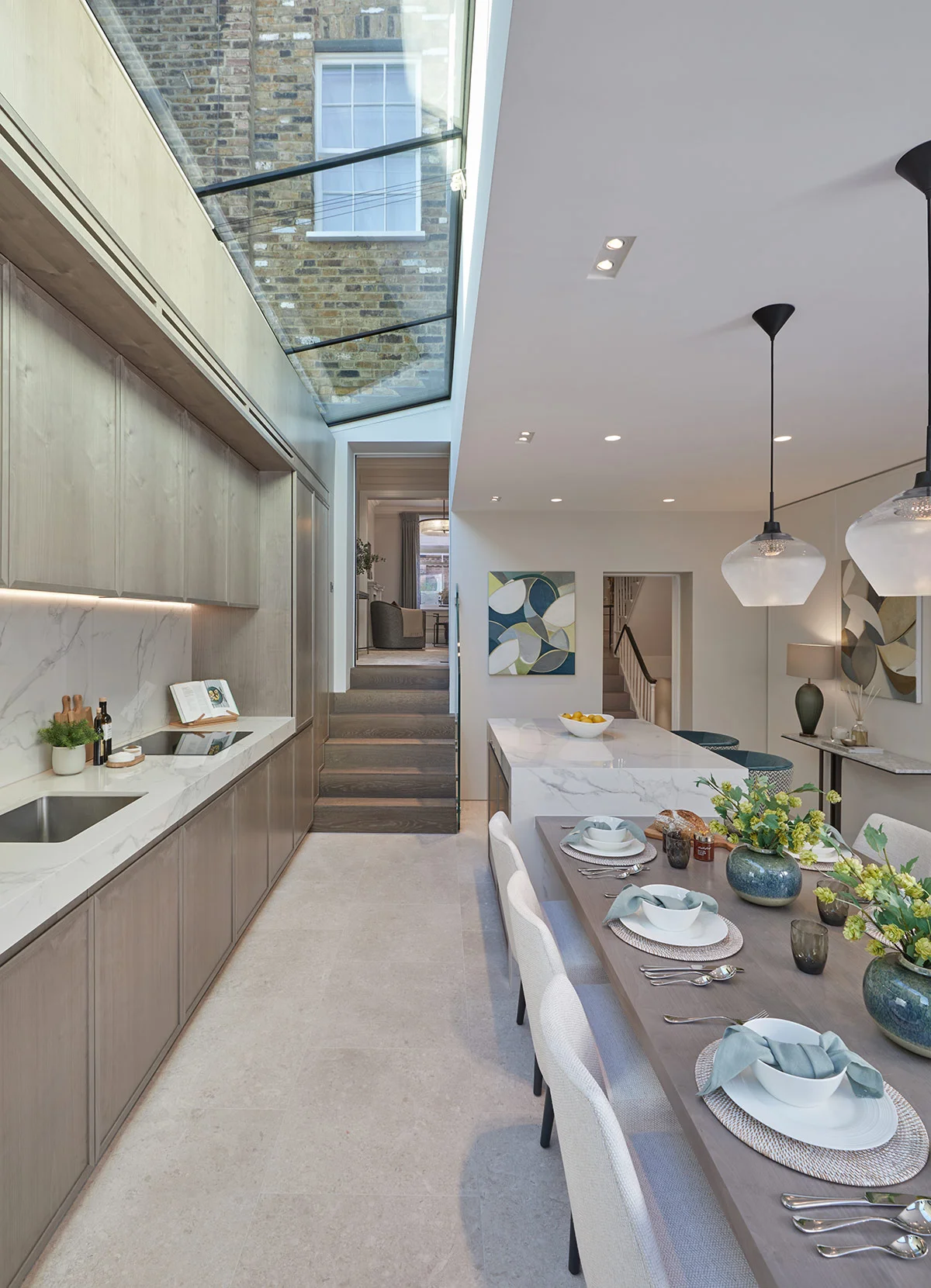 Kitchen island with marble worktop, bar seating, and styled dining table.