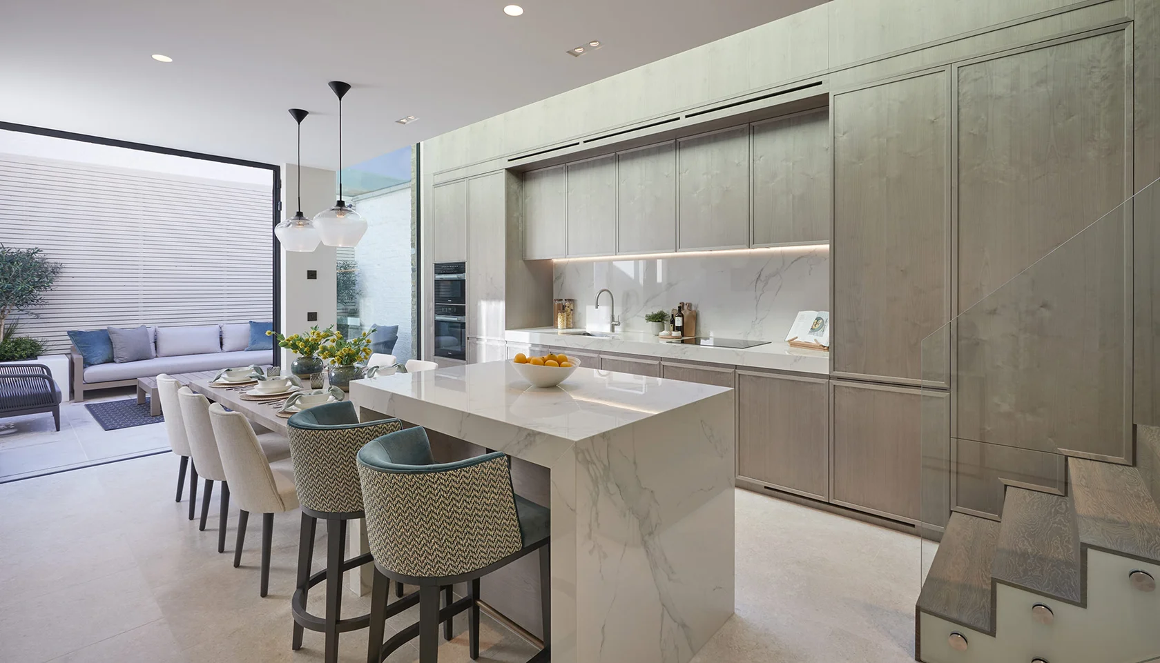 Bespoke kitchen and dining space with full-height cabinetry and glazed roof light.
