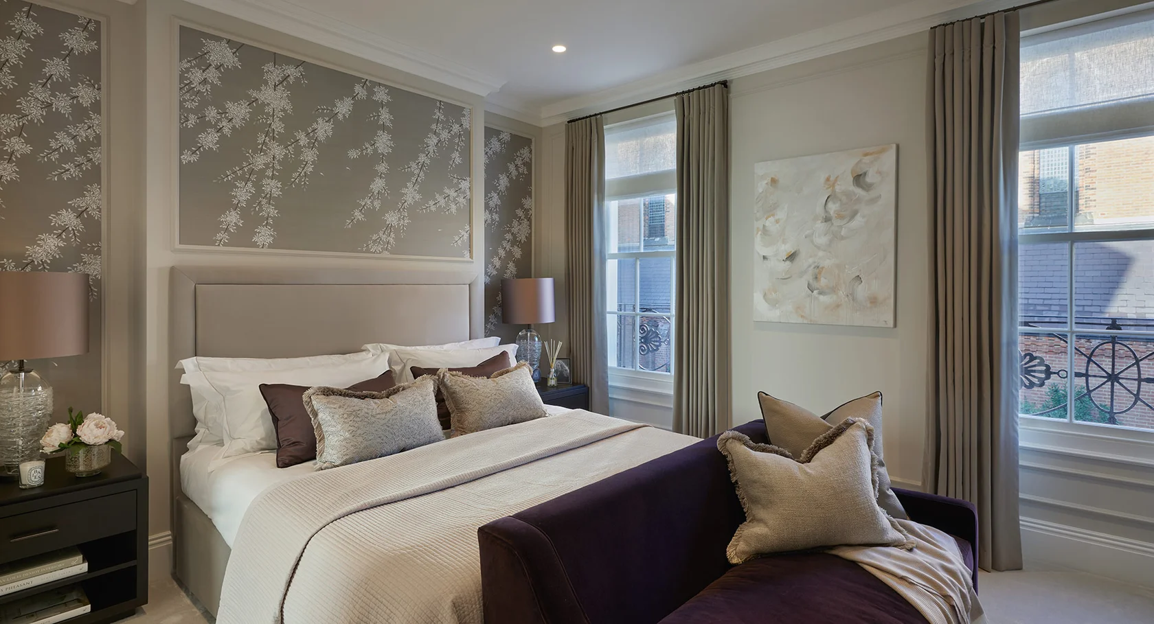 Bedroom seating area with upholstered bench, cushions, and framed artwork.