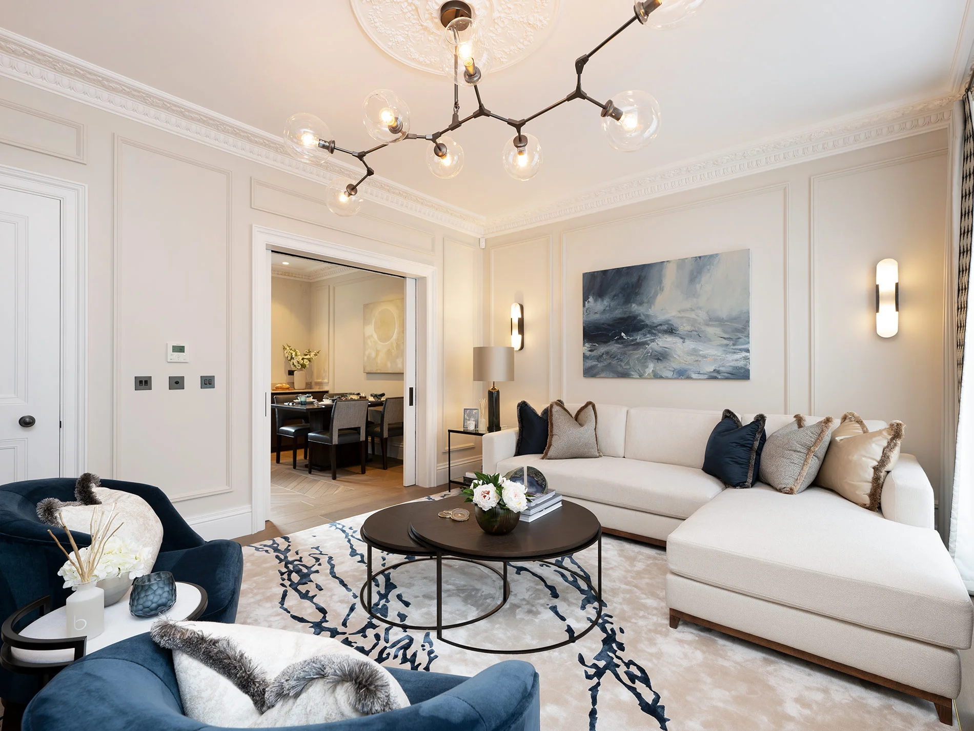 Stylish living room with a sectional sofa, modern lighting, and decorative artwork, featuring a cozy atmosphere.