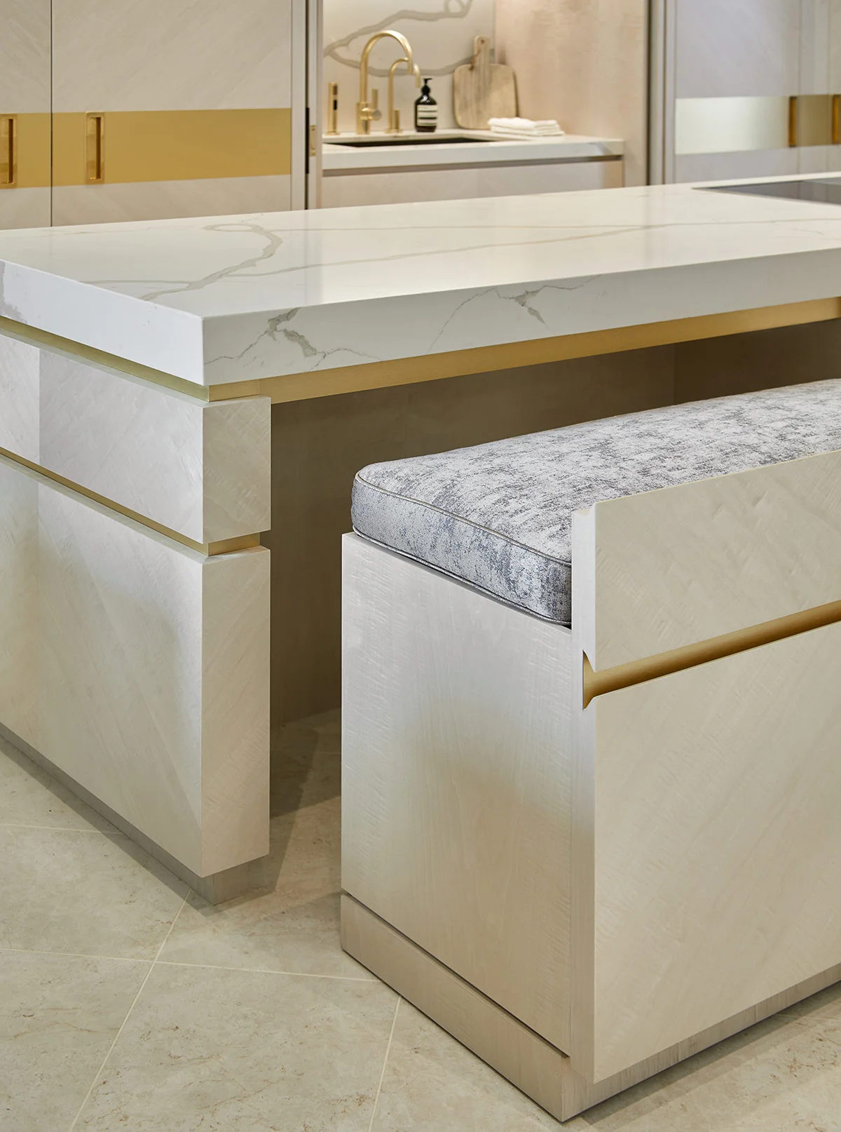 Modern kitchen island with a marble countertop and minimalist design featuring a cushioned bench.