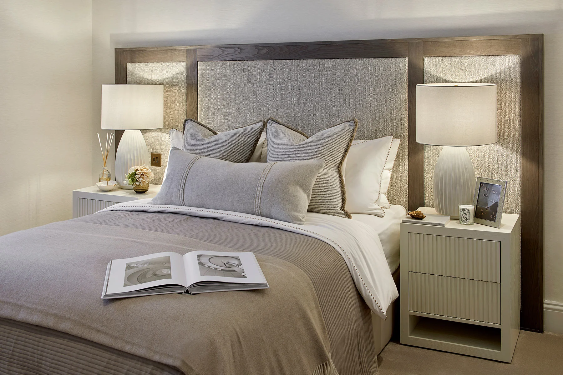 Elegant double bed with decorative cushions and soft bedside lights.