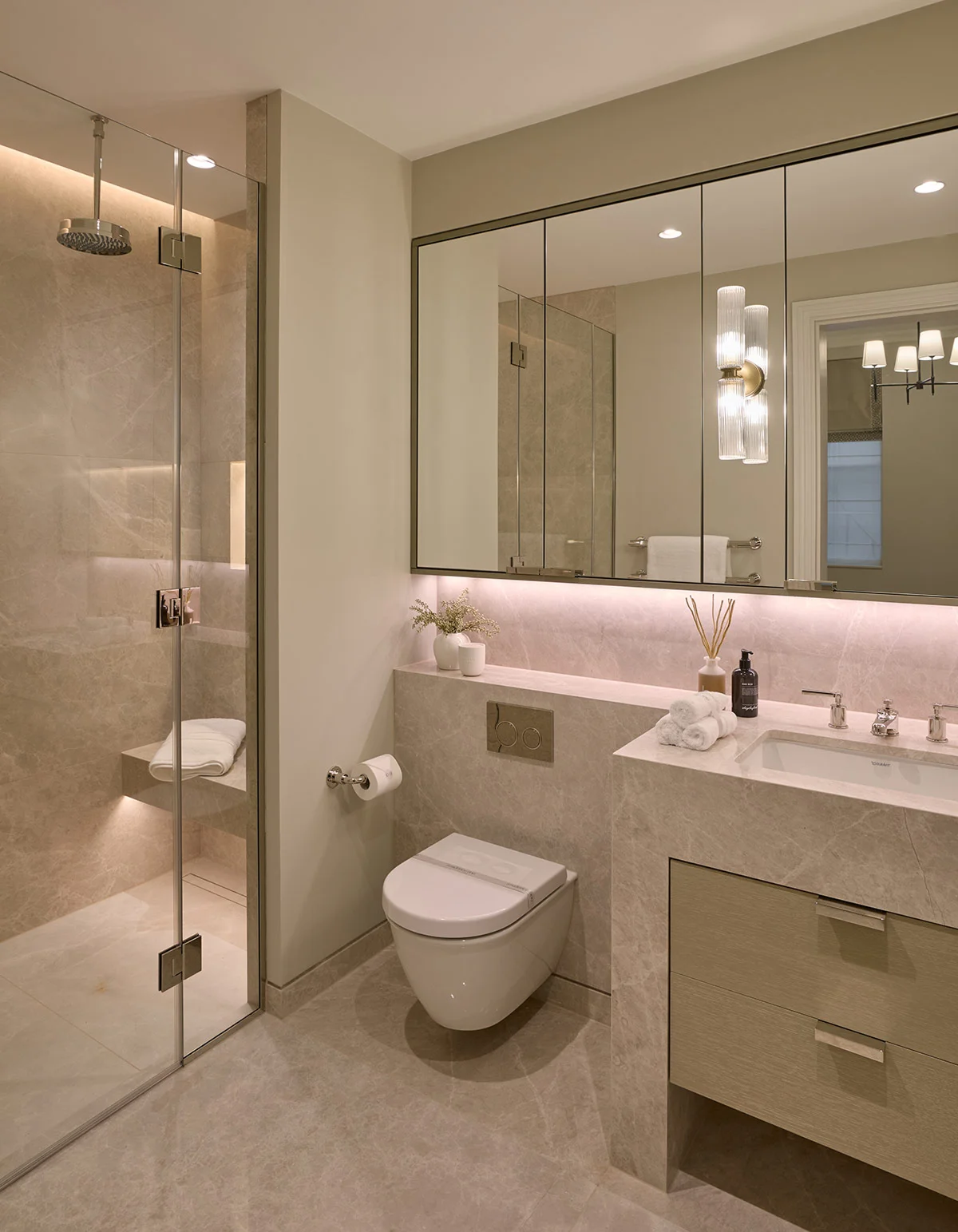 Modern bathroom featuring a glass shower, elegant vanity, and stylish lighting. Neutral tones and sleek design.