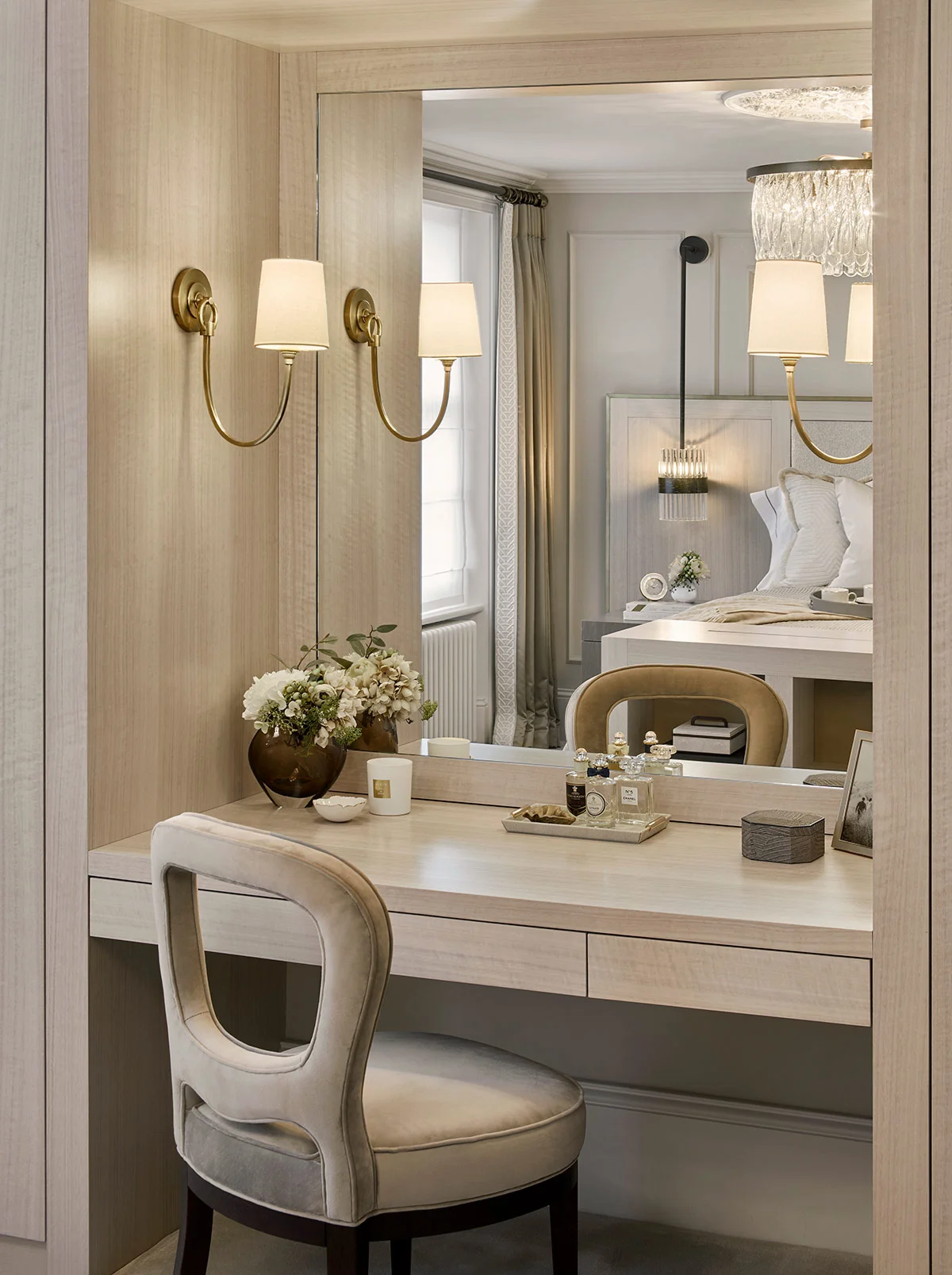 Elegant vanity with a chair, decorative wall sconces, and a mirror in a stylish room setting.