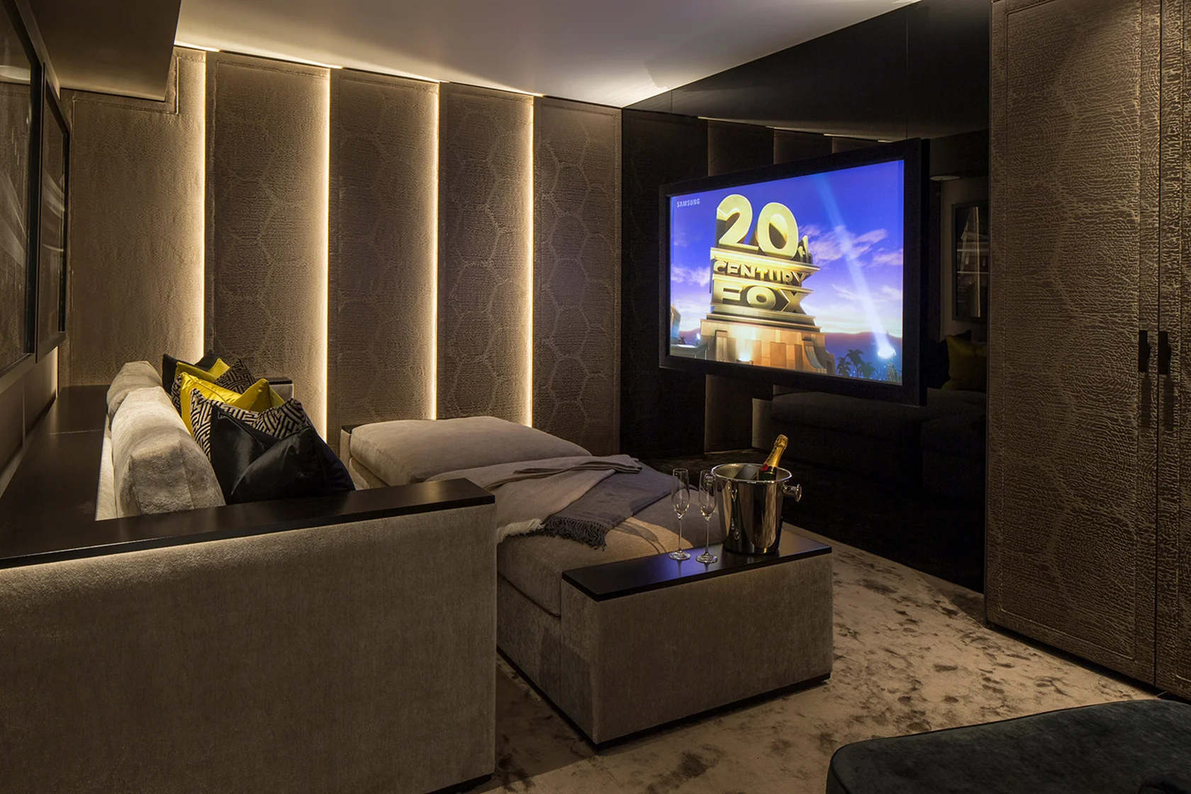 Cozy movie room featuring a large screen displaying "20th Century Fox" and stylish seating with soft lighting.