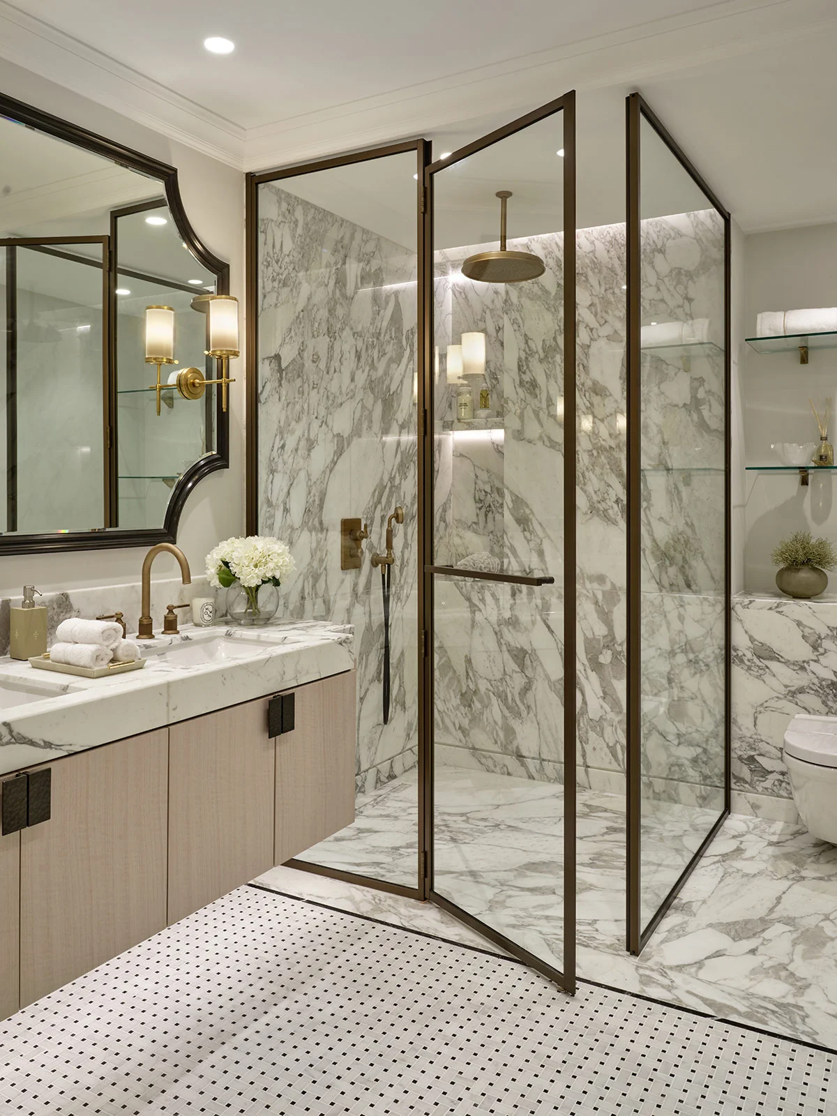Modern bathroom featuring a marble shower, elegant fixtures, and a stylish vanity with decorative lighting.