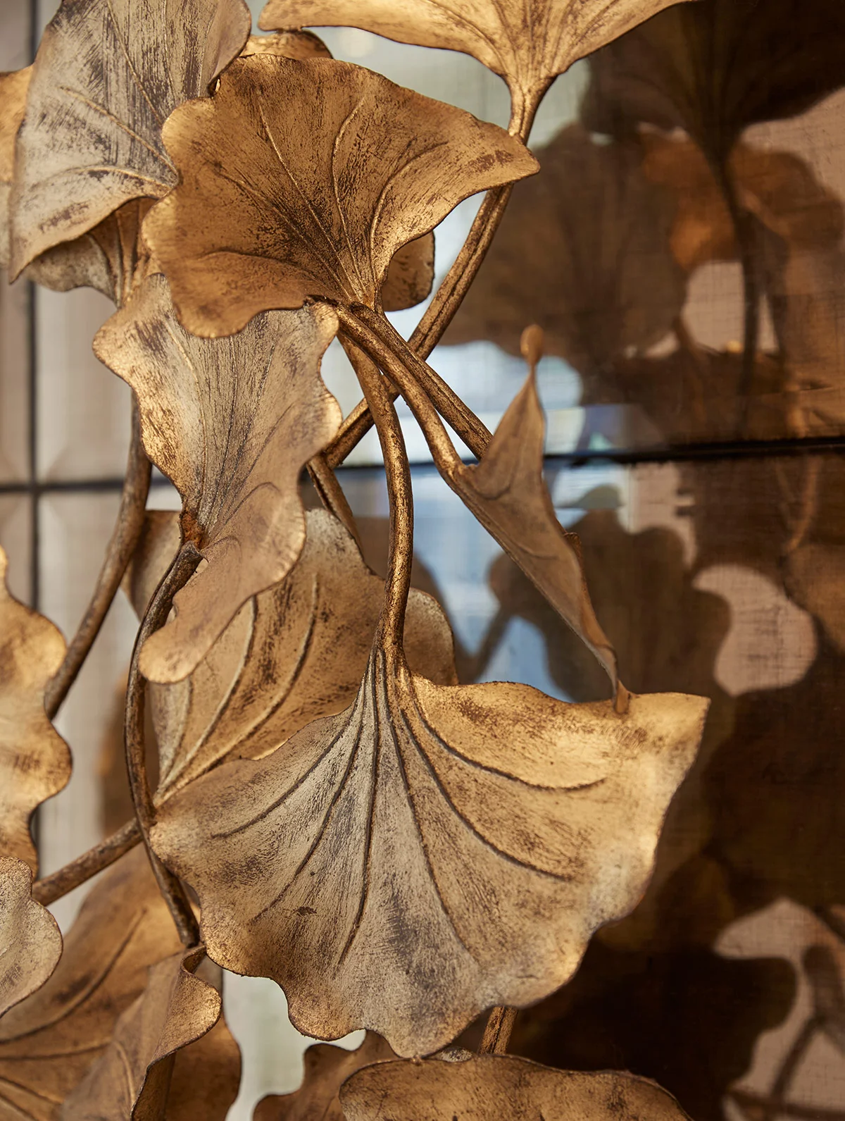Decorative metal wall art featuring intricate, textured designs of large leaves.